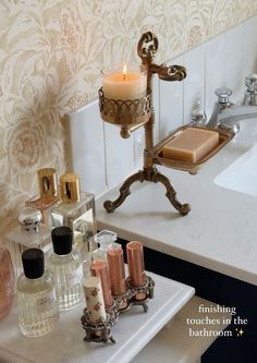 a bathroom sink with candles and soaps on it