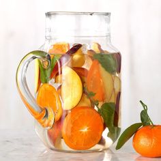 a glass jar filled with sliced oranges and apples