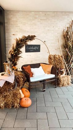 an outdoor seating area with hay and pumpkins