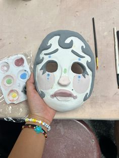 a person is painting a mask on a table