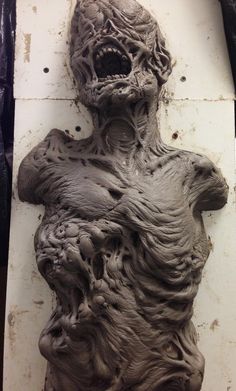 a sculpture made out of clay on top of a white board with holes in it