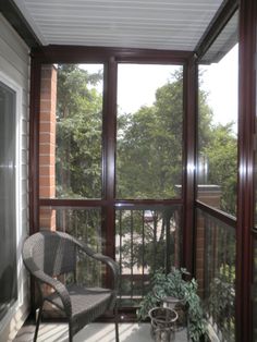 a chair sitting on top of a porch next to a window