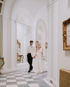 a bride and groom are walking down the hall