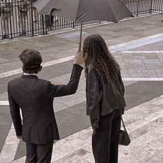 two people walking down the street holding an umbrella