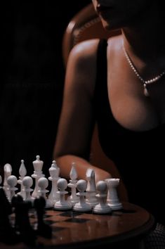 a woman sitting in front of a chess board