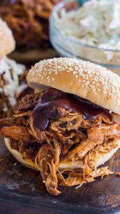 a pulled pork sandwich with bbq sauce and cole slaw on the side, ready to be eaten