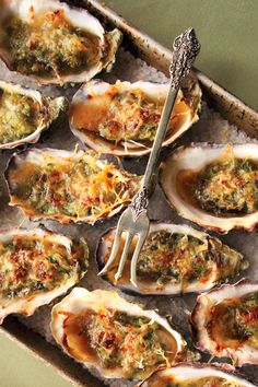 a tray filled with lots of oysters covered in sauce