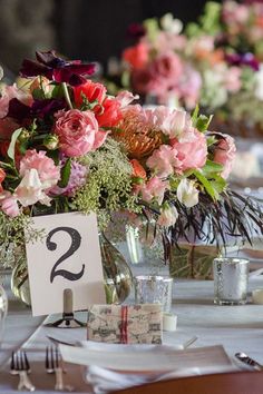 the table is set with flowers and place cards