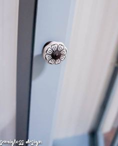 a door handle on the side of a blue door with white curtains in the background