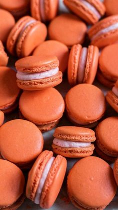 an assortment of orange macaroons on display