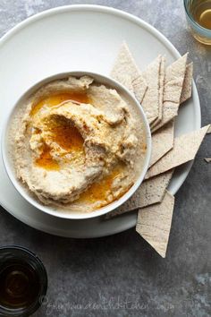 hummus and crackers on a white plate