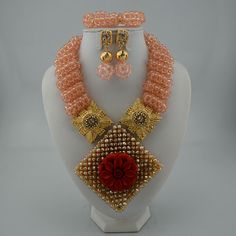 a necklace and earring set on a mannequin headpiece with beads, pearls, and red flowers