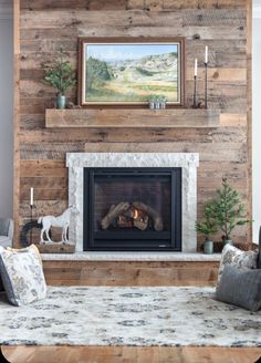 a living room with a fire place in the center and a painting on the wall