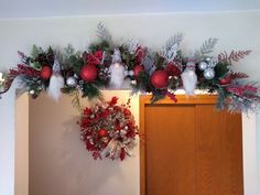 christmas decorations hanging on the wall above a door