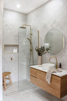 a bathroom with a sink, mirror and stand up shower stall in it's corner