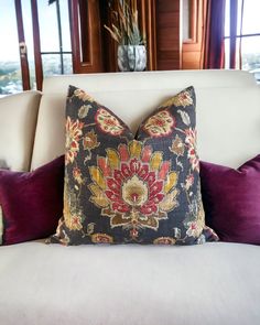 a decorative pillow on a white couch in a living room