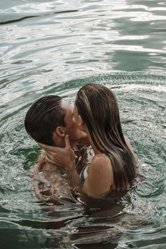 a man and woman kissing in the water