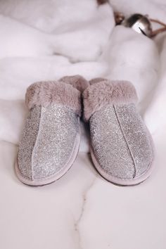 This fully lined faux fur slip on is a staple for your house. They are so beautiful and trendy they would also make the perfect gift for the holidays. Round toe, silver glitter upper Soft cushy insole with slip resistant rubber tread Fits true to size Only available in whole sizes. If you are a half size, size up. ﻿* Screen resolution/lighting may alter item color/design and brightness Cheap Gray Slip-on Slippers, Sparkly Ugg Slippers, Luxury Chic Slip-on Slippers, Glass Slipper Pillow, Sequin Ugg Slippers, Silver Glitter, Slide Slipper, So Beautiful, Faux Fur