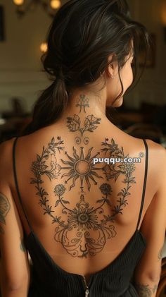 the back of a woman's body with tattoos on her upper and lower back