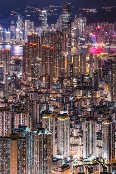 an aerial view of the city at night with skyscrapers lit up in bright colors