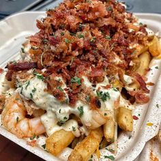 a white plate topped with fries covered in cheese and bacon