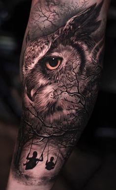 an owl with two people on a swing in front of it's eyes and tree branches