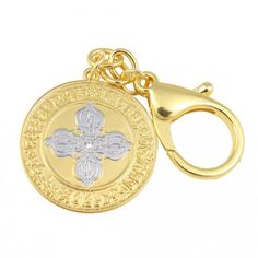 a gold keychain with a cross on the front and an emblem on the back