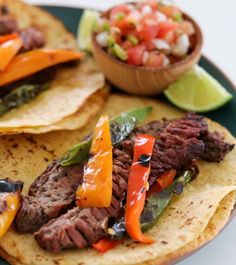 steak fajitas with peppers and salsa on a plate