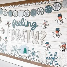 a wooden sign that says feeling frosty? with snowmen and christmas decorations on it