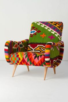 an upholstered colorful chair with wooden legs