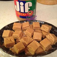 peanut butter and jelly sandwiches on a plate next to a jar of peanut butter sitting on the counter