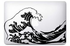 an apple laptop with the great wave on it's back cover in black and white