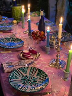 the table is set with candles and plates