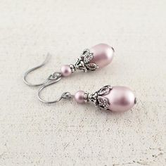 Powder Rose Swarovski crystal pearls dressed with antiqued silver filigree and adornments for an Old-World feel. The beads are an elegant shade of soft, subdued pink. ---------------------------------------------------------------------------------------------Dimensions and details: - Swarovski pearl teardrops measure 11 mm in height - From the top of the hook ear wires to the bottom of the earrings, they measure approximately 1.25 inches (32 mm) - Beads are genuine Swarovski crystal pearls- Fil Classic Pink Earrings For Wedding, Elegant Nickel-free Pink Earrings, Elegant Nickel-free Pink Jewelry, Pink Feminine Pearl Earrings For Wedding, Feminine Pink Pearl Earrings For Wedding, Feminine Pink Pearl Earrings, Elegant Rose Gold Beaded Earrings, Elegant Pink Beaded Jewelry, Classic Pink Pearl Earrings For Wedding