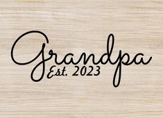 the word grandpa est 202 written in black ink on a wooden surface