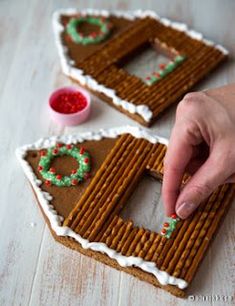 someone is decorating their gingerbread house with icing