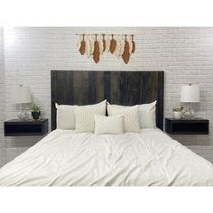 the bed is made with white linens and pillows, along with decorative wall hangings