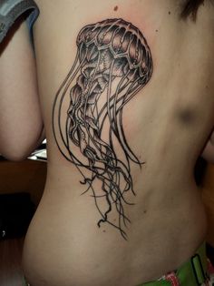 a woman with a tattoo on her stomach has a jellyfish in it's back