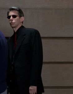 two men in suits and sunglasses walking down the street