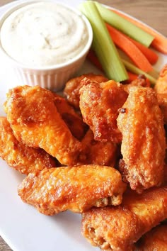 chicken wings and carrots on a plate with ranch dip