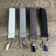 four lanyards with tassels on each one are lined up in different colors