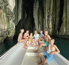 a group of people sitting on the back of a boat in a body of water