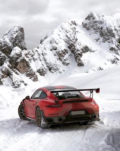 a red sports car driving through the snow