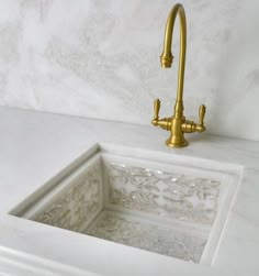 a white sink sitting under a faucet next to a marble counter top in a bathroom