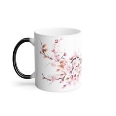 a white coffee mug with pink flowers on the inside and black rims, sitting against a white background