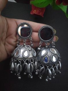 Silver jewelry has always been a great companion for white ethnics, and we are sure our Mirror Silver Oxidised gungroo jhumkis is all you will need to complete your looks. Appealing pair of earrings dressed with dreamy gungroo by the edge of jhumki dome and intricate floral detailing. A funky pair of earrings that adds a story to your look. Silver Jhumkas For Navratri, Handmade Jhumkas For Navratri, Festive Oxidized Finish Jhumkas For Celebration, Traditional Oxidized Jhumkas As Gift, Metal Jhumkas Drop Earrings For Gifts, Oxidized Finish Jhumkas For Gift, Oxidized Jhumkas For Festivals And Gifts, Gift Oxidized Finish Jhumkas For Festivals, Gift Oxidized Finish Jhumkas