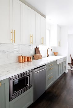 a kitchen with marble counter tops and gold accents on the backsplash, along with stainless steel appliances