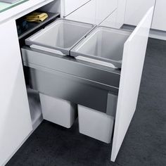 an open cabinet with two bins in the middle and one drawer on the other side