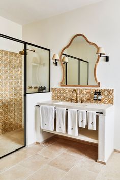 a bathroom with a sink, mirror and towel rack on the wall in front of it