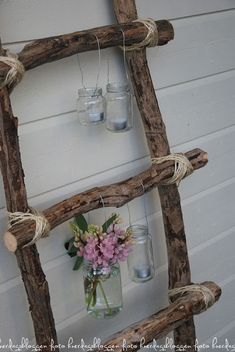 an old ladder is decorated with mason jars and twine rope to hold vases